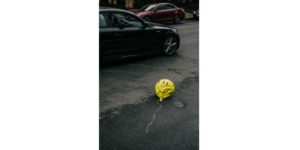 ballon hélium en forme de smiley dégonflé au milieu d'une rue