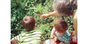 Grand-parent montrant à ses petits-enfants la nature devant eux